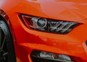 Luxury Cars - Dynamic close-up shot of a shiny orange sports c #12522971