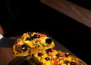 Food Aesthetics - Delicious pizza slice with olives, peppers, and #13062449