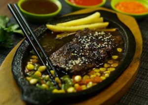 Food Aesthetics - Sizzling steak served with fries and three flavo #29899522