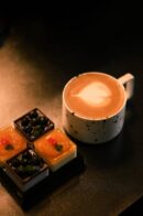 Food Aesthetics - A cup of latte with intricate art alongside asso #35614372