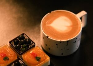 Food Aesthetics - A cup of latte with intricate art alongside asso #35614372