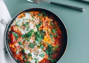 Food Aesthetics - Delicious shakshuka in a pan garnished with fres #6275160